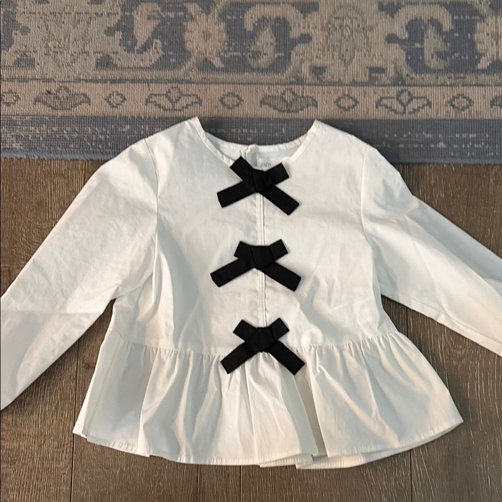 Girls White Peplum Top with Black Bow Accents